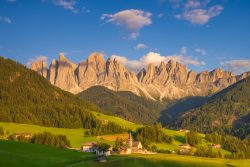 The last golden light on the Odle peaks above Santa Maddalena, Val di Funes, South Tyrol. July 14, 2025. Santa Maddalena church in Val di Funes at sunset, with the Odle peaks of the Dolomites glowing above green meadows