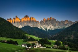 The last golden light on the Odle peaks above Santa Maddalena, Val di Funes, South Tyrol. July 14, 2025. Santa Maddalena church in Val di Funes at sunset, with the Odle peaks of the Dolomites glowing above green meadows